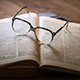 Ein aufgeschlagenes Buch mit Brille